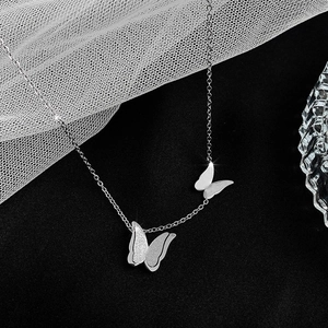 Dettaglio della collana a doppio farfalla con finiture opache e lucide argento