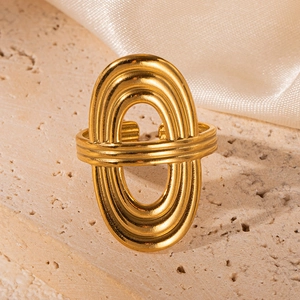 Detail of 18K gold plated hollow geometric ring on elegant silk and stone background