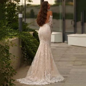 Detail of elegant lace mermaid wedding dress with open back and long sleeves in garden