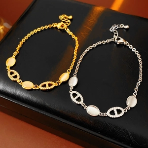 Détail de bracelets or et argent avec pierre œil de chat et maillons nez de cochon
