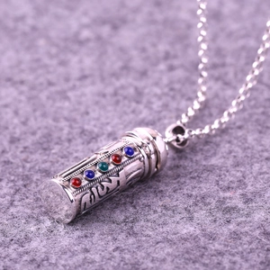 Macro detail of S925 sterling silver cylinder pendant with colorful inlaid gemstones