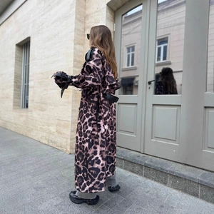 Dettaglio del cappotto leopardato con cinturini in pelle nera su maniche e vita