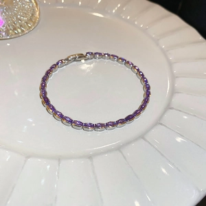 Detail of silver tennis bracelet with oval purple zircon stones and secure folding clasp