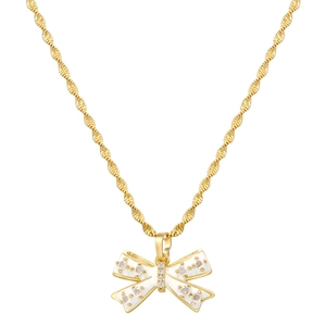Detailed macro view of a gold spiral chain with white enamel bow pendant and zircons