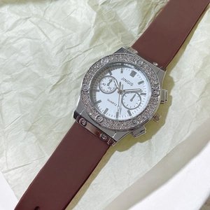 Detailed close-up of JINGIS quartz watch with rhinestone bezel and brown silicone strap
