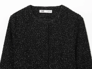 Vue détaillée de l'encolure d'un blazer en tweed noir avec étiquette de marque interne