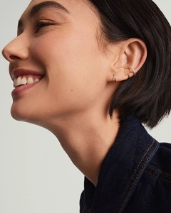 Model wearing gold S925 silver criss-cross earrings and sparkling zircon ear cuff set