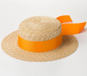 Detailed weave of a natural straw flat top hat with a vibrant orange ribbon decoration