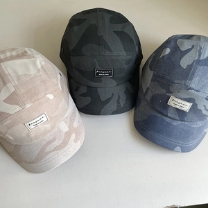 Detailed top view of 5-panel camouflage camper caps with vintage letter patches