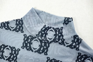 Detailed view of sheer light blue turtleneck mesh with intricate dark blue pattern prints
