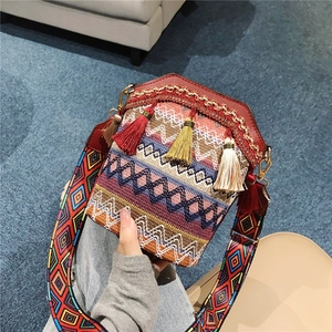 Ethnic bohemian woven crossbody bucket bag with colorful tassels and wide patterned strap