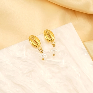 Golden shell earrings with irregular white pearl pendants on a ripple display stand