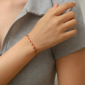 Bohemian gold heart link bracelet with red beads on a minimalist stainless steel chain