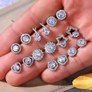 Variety set of silver plated copper flower and heart zircon stud earrings held in hand
