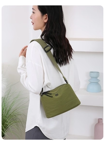 Détail d'un sac bandoulière en nylon vert armée avec sangle réglable et poches zippées