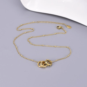 Golden stainless steel necklace with interlocking rings and green zircon pendant