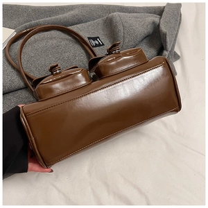 Brown patent leather pillow bag with double front pockets and silver twist lock detail