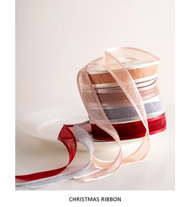 Close-up of semi-transparent Christmas ribbons in elegant red, grey, and champagne tones