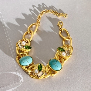Detail of vintage gold chain bracelet with turquoise, green gems, and white pearls