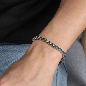 Polished silver box chain bracelet for men in stainless steel on a model wrist
