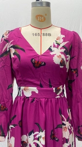 Vue détaillée de la robe magenta à col en V avec motifs de fleurs blanches et papillons