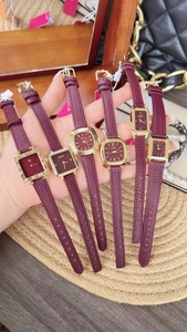 Close-up of vintage burgundy leather strap watches with gold cases in various shapes