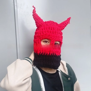 Detail of red and black knit balaclava mask featuring prominent devil horns for costumes