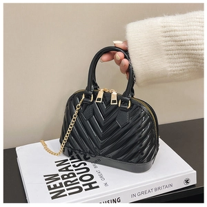 Detailed close-up of glossy black jelly shell bag with V-shaped texture and gold zipper