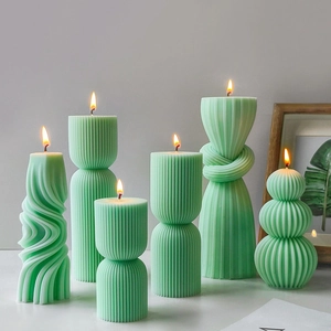 Pale green pillar candles set with twisted and ribbed textures in artistic shapes