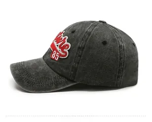 Detail of vintage washed denim baseball cap with side embroidery patch 85 in dark grey color