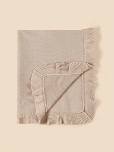 Close-up of soft beige cotton knit baby blanket with elegant ruffle edge detail