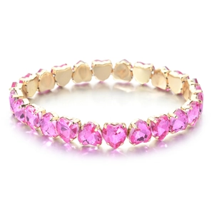 Macro view of heart-shaped pink zircon stones set in a gold plated tennis bracelet