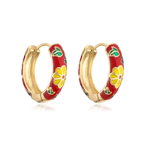 Close-up of gold-plated hoop earrings with red floral enamel patterns and tiny details