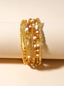 Detailed macro view of stacked handmade glass seed bead bracelets in earthy warm tones