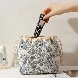 Detailed shot of beige quilted floral pouch being used for storing skincare cosmetics
