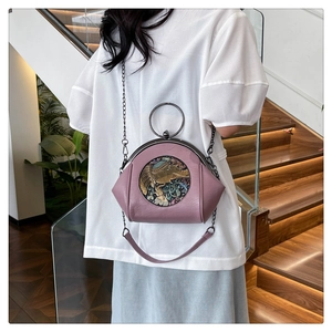 Detail of lavender leather shell bag with round metal handle and elephant relief carving