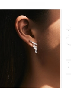 Close-up of s925 silver dangle earrings with sparkling teardrop crystals on a model