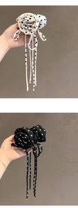 Detail of fabric rose hair claw clips with black and white polka dot ribbons