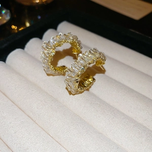 Close-up of gold hoop earrings with wrapped crystal Baguette stones on a velvet tray