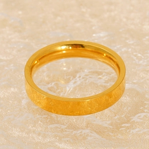 Close-up of a minimalist 18k gold-plated stainless steel ring on lace fabric