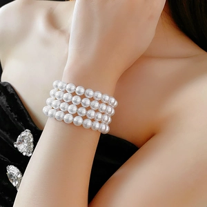 Bracelet élégant à quatre rangs de perles blanches au poignet, accessoire vintage chic