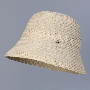 Detailed close-up of beige straw bucket hat with hollow weave and pearl flower accent