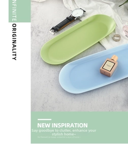 Close-up of elegant oval jewelry trays in pastel green and blue on marble surface