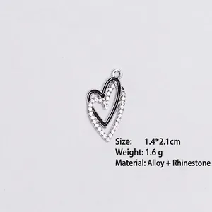 Macro view of double heart alloy pendant with rhinestones measuring 1.4 by 2.1cm
