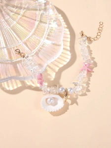 Detail of beach bracelet featuring shell pearl pendant, pink starfish, and pebble beads