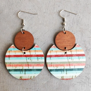 Detailed macro view of bohemian C-shaped striped wood earrings on grey texture