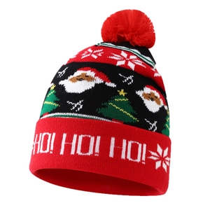 Christmas knit beanie with red pompom featuring Santa Claus, trees, and HO HO HO text