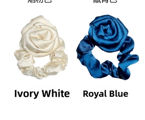 Detailed view of large satin rose hair ties in ivory white and royal blue colors