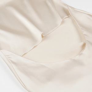 Close-up of champagne satin fabric with elegant 3D flower detail on halter neck back