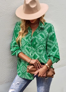 Detail of green paisley print long sleeve blouse with elegant floral patterns on fabric